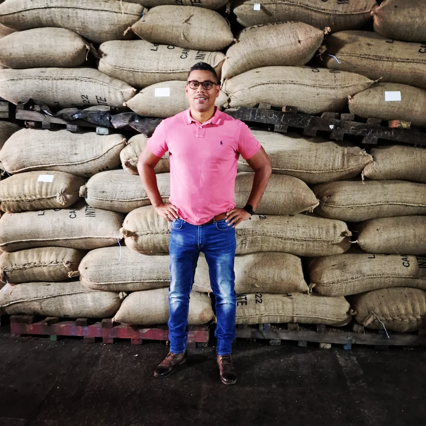 Jean-Paul Ogou, fondateur d'Orion Agro Tech & Trade, devant des sacs de cacao à Affery, Côte d'Ivoire
